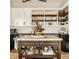 Bright kitchen featuring a kitchen island, white cabinets and open shelving above dark granite countertops at 3675 Dartmoor Way, Zionsville, IN 46077