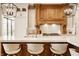 Bright kitchen featuring a large island with seating and custom wooden range hood at 3675 Dartmoor Way, Zionsville, IN 46077