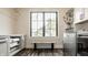 Bright laundry room with a front loading washer/dryer, custom cabinets and hardwood floors at 3675 Dartmoor Way, Zionsville, IN 46077