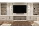 Bright living room featuring custom shelving, large flat screen television, and comfortable seating with an ottoman at 3675 Dartmoor Way, Zionsville, IN 46077