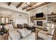 Bright living room featuring a stone fireplace, wooden beams, and comfortable seating area at 3675 Dartmoor Way, Zionsville, IN 46077