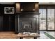 Comfortable living room featuring fireplace, black mantel, hardwood floors, and glass patio doors at 3675 Dartmoor Way, Zionsville, IN 46077