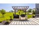 This outdoor kitchen features a grill and pergola with a beautiful green yard and neighborhood in the background at 3675 Dartmoor Way, Zionsville, IN 46077