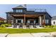 Beautiful outdoor living space with a stone fireplace, covered patio, and comfortable seating at 3675 Dartmoor Way, Zionsville, IN 46077