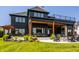 Expansive patio with a stone fire pit, covered area, and beautifully landscaped yard at 3675 Dartmoor Way, Zionsville, IN 46077
