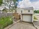 Backyard view of the home with a detached garage, chain link fence and side entrance at 4025 Main St, Anderson, IN 46013