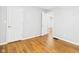 A light and airy bedroom with hardwood floors and two white doors, offering a minimalist aesthetic at 4025 Main St, Anderson, IN 46013