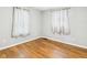 A simple bedroom featuring hardwood floors and a pair of curtained windows for a cozy ambiance at 4025 Main St, Anderson, IN 46013