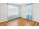 A light and airy bedroom with hardwood floors and a pair of light blue curtained windows at 4025 Main St, Anderson, IN 46013
