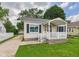 Charming front exterior with a covered porch, white railing, and a well-maintained lawn at 4025 Main St, Anderson, IN 46013