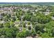 A wide aerial view showcasing a residential area near a town, surrounded by vibrant greenery at 409 N Sycamore St, Martinsville, IN 46151