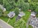 An aerial view of a property and its detached garage surrounded by lush trees and green lawns at 409 N Sycamore St, Martinsville, IN 46151