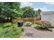 Charming backyard with a brick patio, outdoor grill, picnic table, and lush garden at 409 N Sycamore St, Martinsville, IN 46151