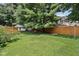Large, grassy backyard showcasing mature trees and a fence, offering a private and serene outdoor space at 409 N Sycamore St, Martinsville, IN 46151