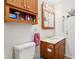 Bathroom featuring wooden vanity, overhead cabinets, and illuminated mirror at 409 N Sycamore St, Martinsville, IN 46151