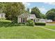 Charming single-story home with mature landscaping, red shutters, and a detached two-car garage at 409 N Sycamore St, Martinsville, IN 46151