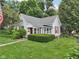 Well-maintained home with red accents, mature landscaping, and a lush green lawn, creating curb appeal at 409 N Sycamore St, Martinsville, IN 46151