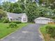 Inviting home with a long driveway leading to a detached two-car garage, complemented by a well-kept lawn at 409 N Sycamore St, Martinsville, IN 46151