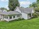 A view of the back exterior of the home, featuring white siding and a well-maintained yard at 409 N Sycamore St, Martinsville, IN 46151