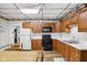 Eat-in kitchen featuring oak cabinets, white appliances, and wood-look flooring at 409 N Sycamore St, Martinsville, IN 46151