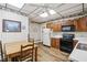 Eat-in kitchen featuring white appliances, oak cabinets, and wood-look flooring at 409 N Sycamore St, Martinsville, IN 46151