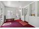 Enclosed porch with multiple entryways, red carpet, and ample natural light at 409 N Sycamore St, Martinsville, IN 46151