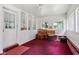 Bright sunroom with multiple windows, red carpet, and white walls at 409 N Sycamore St, Martinsville, IN 46151