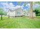 Exterior view of the home's backyard with green grass and chainlink fence in a residential neighborhood at 4210 Main St, Anderson, IN 46013