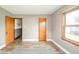 Bright bedroom with wood-look floors, natural light from a window, and neutral walls at 4210 Main St, Anderson, IN 46013