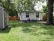 Landscaped backyard featuring a patio, lush green lawn, shed, and wood fence, perfect for outdoor gatherings at 4445 Kingsley Dr, Indianapolis, IN 46205