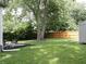 Inviting backyard features a patio, large tree, shed, and wooden fence at 4445 Kingsley Dr, Indianapolis, IN 46205