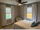 Bright bedroom with hardwood floors, two windows, chair, and inviting bed with accent pillows at 4445 Kingsley Dr, Indianapolis, IN 46205