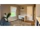 Bright bedroom with a white desk, chair, shelf, and large window overlooking lush greenery at 4445 Kingsley Dr, Indianapolis, IN 46205