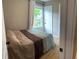 Inviting bedroom with hardwood floors, large window, and comfortable bed with a brown patterned blanket at 4445 Kingsley Dr, Indianapolis, IN 46205
