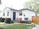 Quaint home featuring fresh landscaping, new wooden fencing, and a welcoming blue front door at 4445 Kingsley Dr, Indianapolis, IN 46205