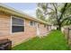 View of backyard, showing stone facade, green grass and partial privacy fence at 4514 Priscilla Ave, Indianapolis, IN 46226