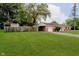 Expansive front yard with attached garage and carport, mature trees, and partial privacy fence at 4514 Priscilla Ave, Indianapolis, IN 46226