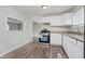 Modern kitchen with wood-look flooring, white cabinets, and stainless steel oven at 4514 Priscilla Ave, Indianapolis, IN 46226