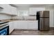 Well-lit kitchen featuring white cabinets, stainless steel refrigerator, and wood-look flooring at 4514 Priscilla Ave, Indianapolis, IN 46226