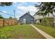 A home with a backyard featuring a small deck, a well-kept lawn, and a wooden privacy fence at 517 N Alton Ave, Indianapolis, IN 46222