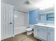 Bright bathroom featuring white vanity with modern sink and faucet, matching toilet, and shower/tub combo with white tile at 517 N Alton Ave, Indianapolis, IN 46222