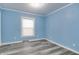 Bright bedroom with light blue walls, white trim, and stylish gray wood flooring at 517 N Alton Ave, Indianapolis, IN 46222