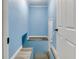 Hallway with light blue walls and gray flooring featuring white trim and access to staircase at 517 N Alton Ave, Indianapolis, IN 46222