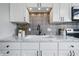 Close up of a modern kitchen sink with marble countertops and white cabinetry at 5503 Antoneli Ln, Indianapolis, IN 46237