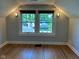 Bright attic space with hardwood floors, two windows, and wall-mounted lighting at 5786 N Delaware St, Indianapolis, IN 46220