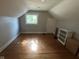 Finished attic space with hardwood floors, unique windows, and neutral paint palette at 5786 N Delaware St, Indianapolis, IN 46220