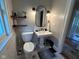 Charming bathroom with pedestal sink, decorative shelves, and stylish tile flooring at 5786 N Delaware St, Indianapolis, IN 46220
