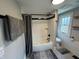 Bright bathroom featuring a white tub with black fixtures, and a window that provides natural light at 5786 N Delaware St, Indianapolis, IN 46220
