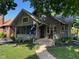 Charming home featuring a covered porch with a bench and inviting landscaped yard at 5786 N Delaware St, Indianapolis, IN 46220