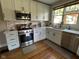 Well-lit kitchen featuring stainless steel appliances, white cabinets, and a garden window at 5786 N Delaware St, Indianapolis, IN 46220